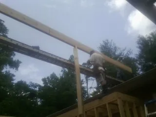 Carpenter setting a ridge beam over a new addition frame — Ice Dam Removal by Roofing Brothers in Bosque Farms