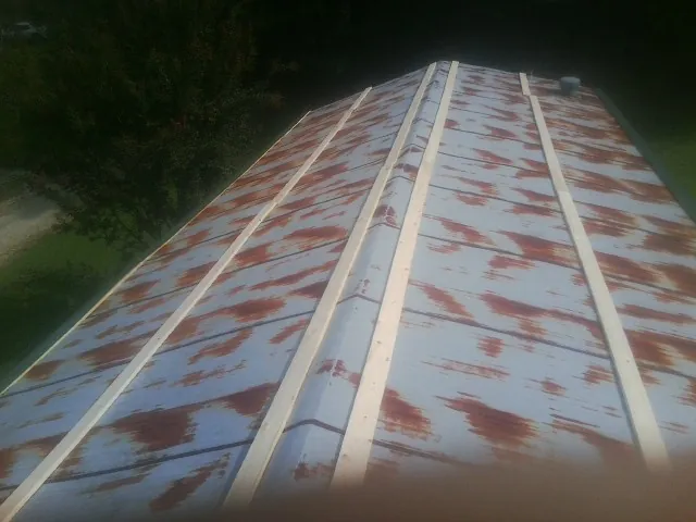 Rusted metal roof panels with new wood purlins before replacement — Storm Damage Roof Repair in Bosque Farms by Roofing Brothers