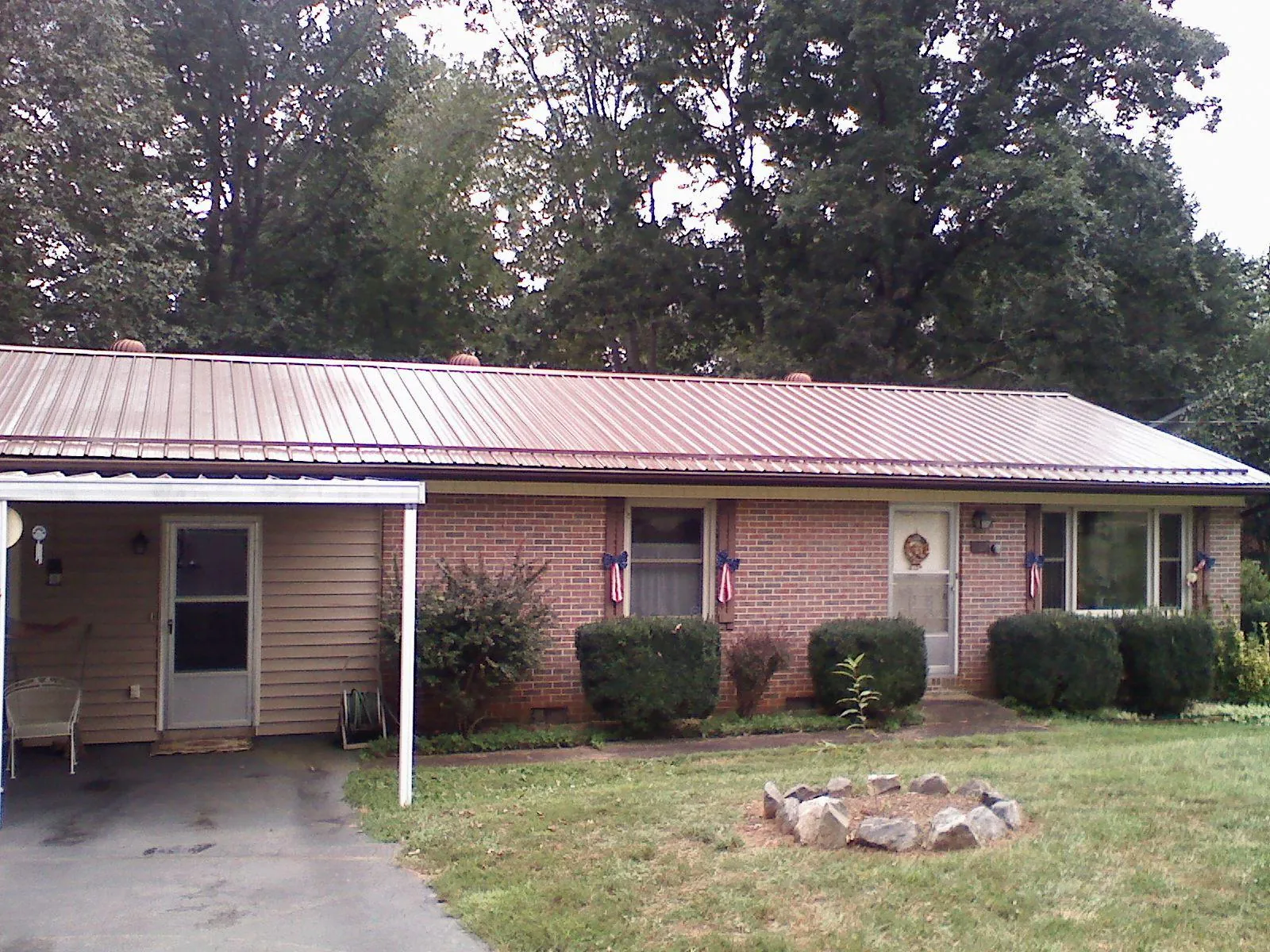 Bronze metal roof and carport on a brick ranch home — Roof Repair work by our crew in Bosque Farms